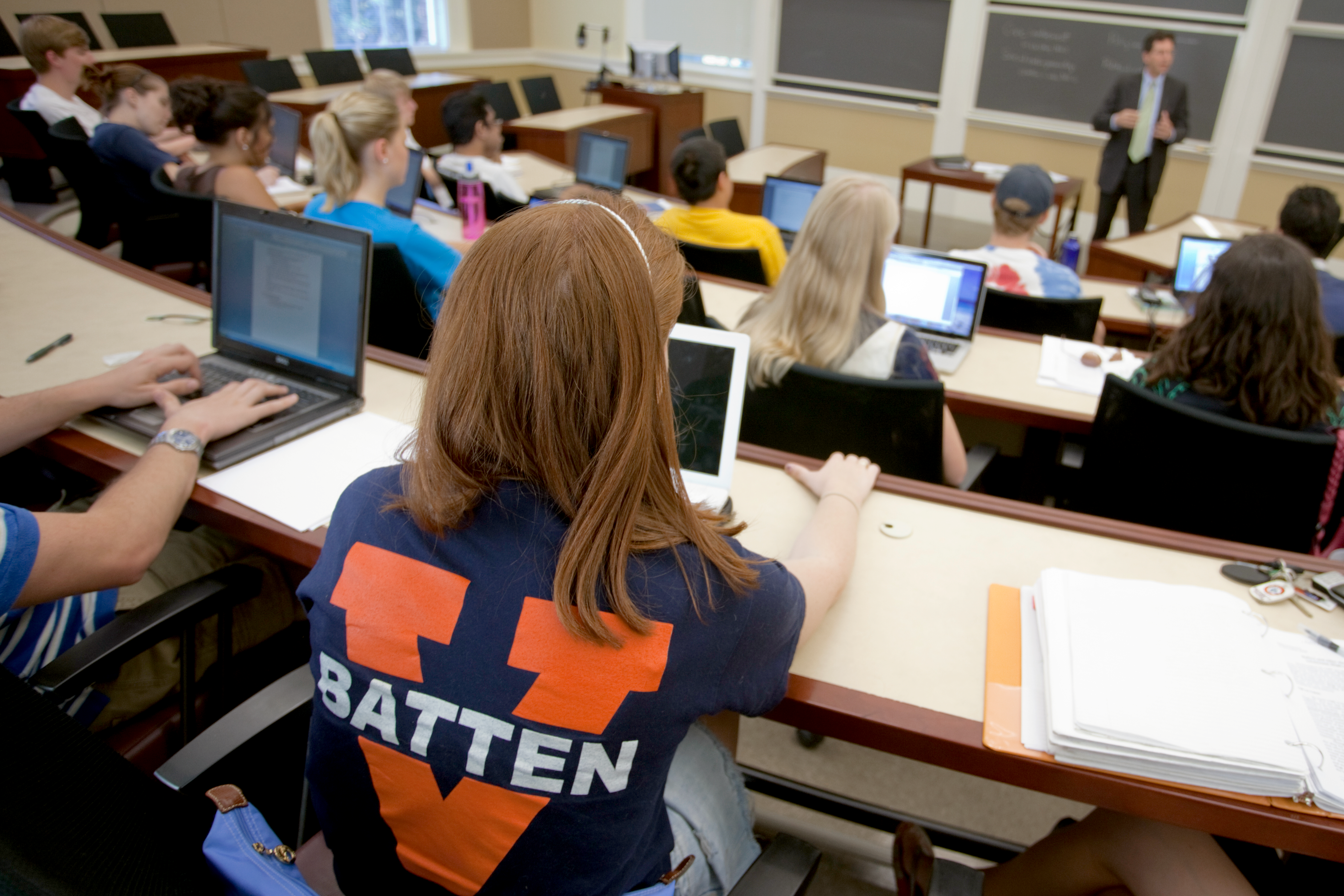 Student with Batten t-shirt looking at a professor speaking in front of class