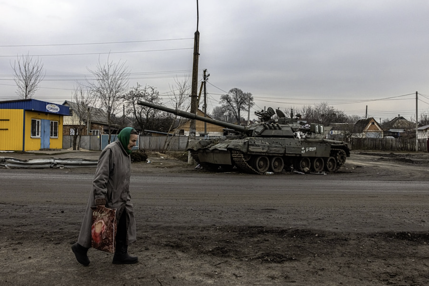 An elderly woman walks past a damaged Russian tank in the town of Trostianets in the Sumy region of Ukraine on March 30. (Roman Pilipey/EPA-EFE/REX/Shutterstock)