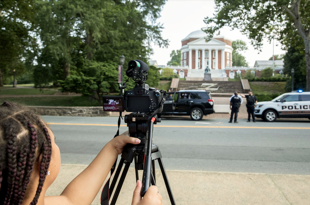 A student films a staged traffic stop in front of the Rotunda as part of the Youth, Blue & U project designed to bring local youths and studentscloser to police officers. (Photos by Dan Addison, University Communications)