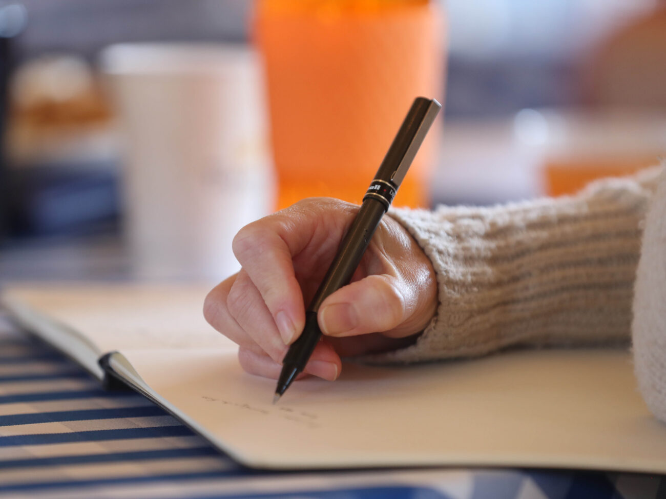 pen in hand writing on paper