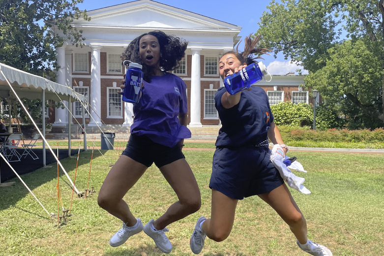 Two Batten BA students express their enthusiasm while showing off the reusable water bottles they received during the event.